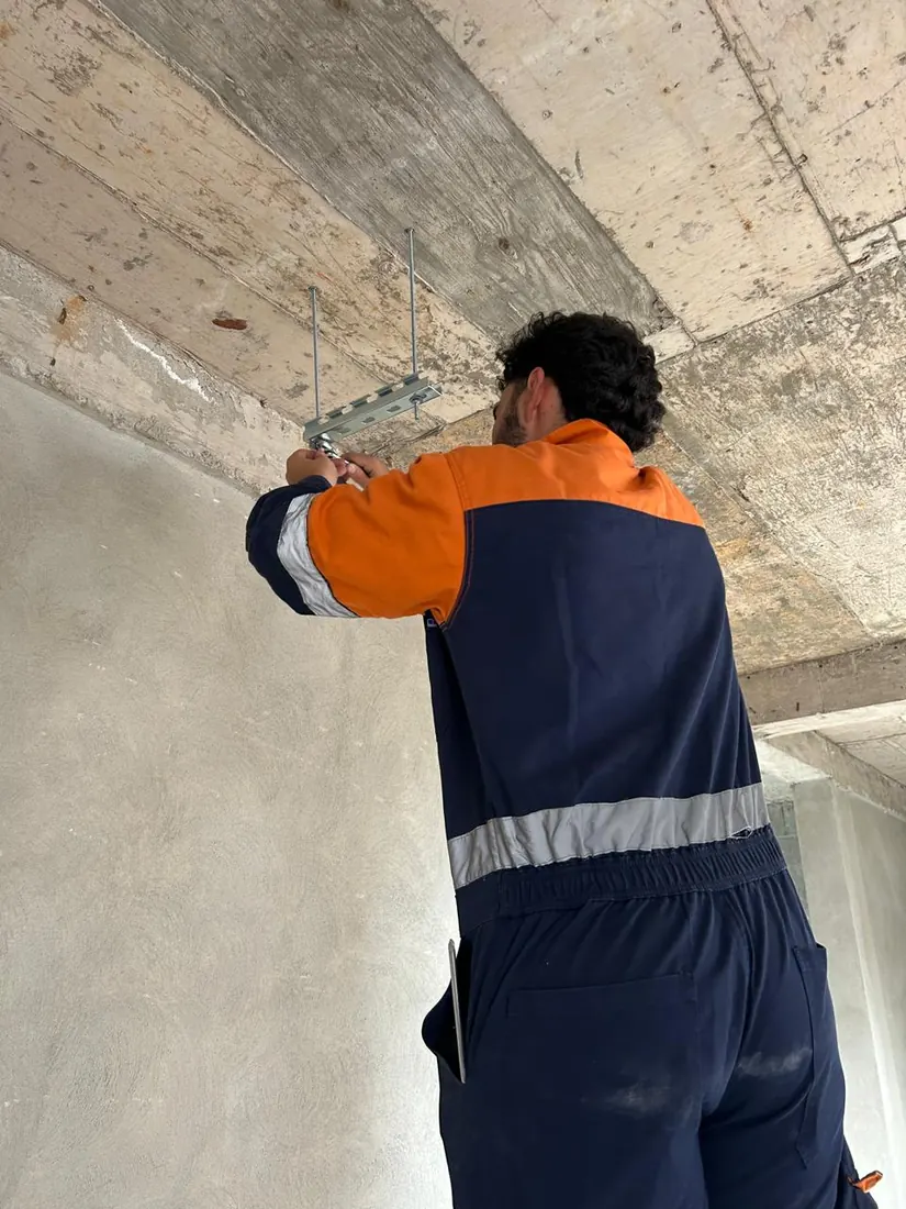 Técnico de DAVALTECH fijando a la losa el soporte de una charola portacables